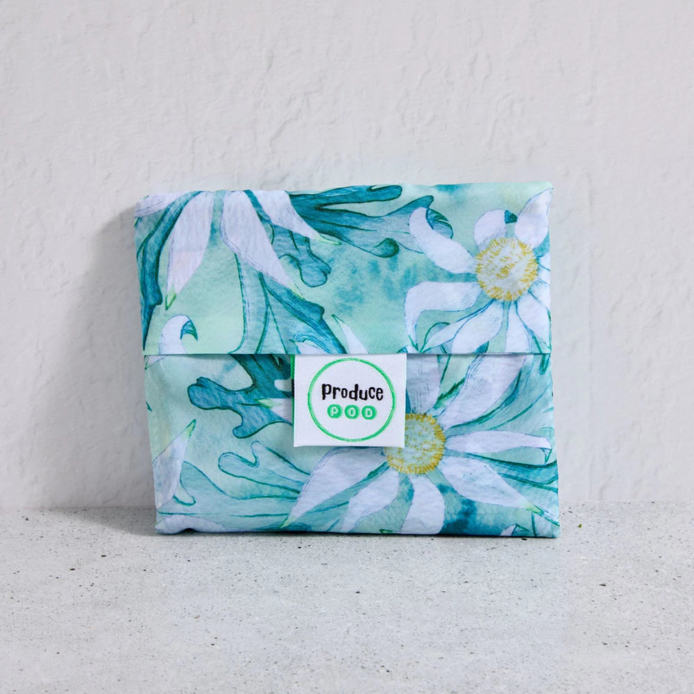 Floral-patterned shopper bag folded up with a visible brand label on a light background