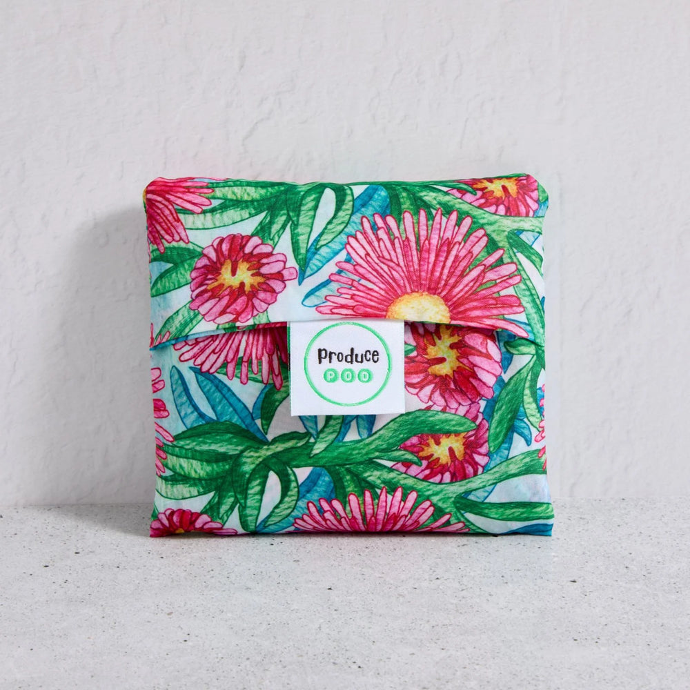 Floral-patterned shopper bag folded up with a visible brand label on a light background