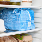 Blue reusable produce bag on a fridge shelf