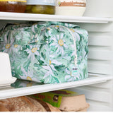Green floral reusable produce bag on a fridge shelf