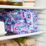 Purple floral reusable produce bag on a fridge shelf