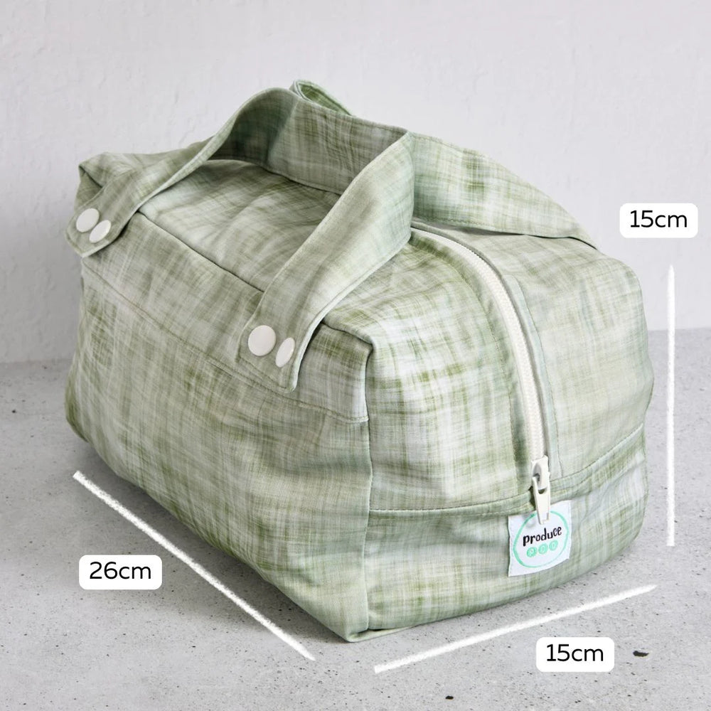 Green reusable produce bag with measurements on a grey background