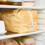 Yellow reusable produce bag on a fridge shelf
