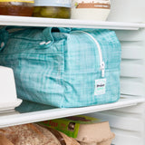 Teal reusable produce bag on a fridge shelf