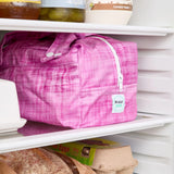 Pink reusable produce bag on a fridge shelf