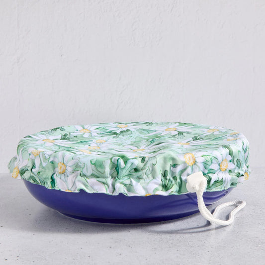 Floral bowl cover on a blue bowl on a light grey background