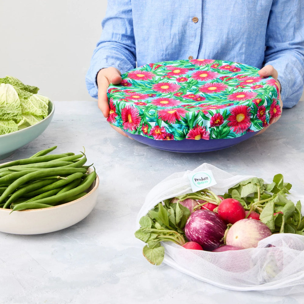 Person holding a reusable bowl cover on a blue bowl