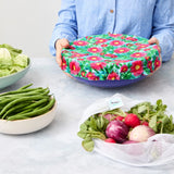 Person holding a reusable bowl cover on a blue bowl
