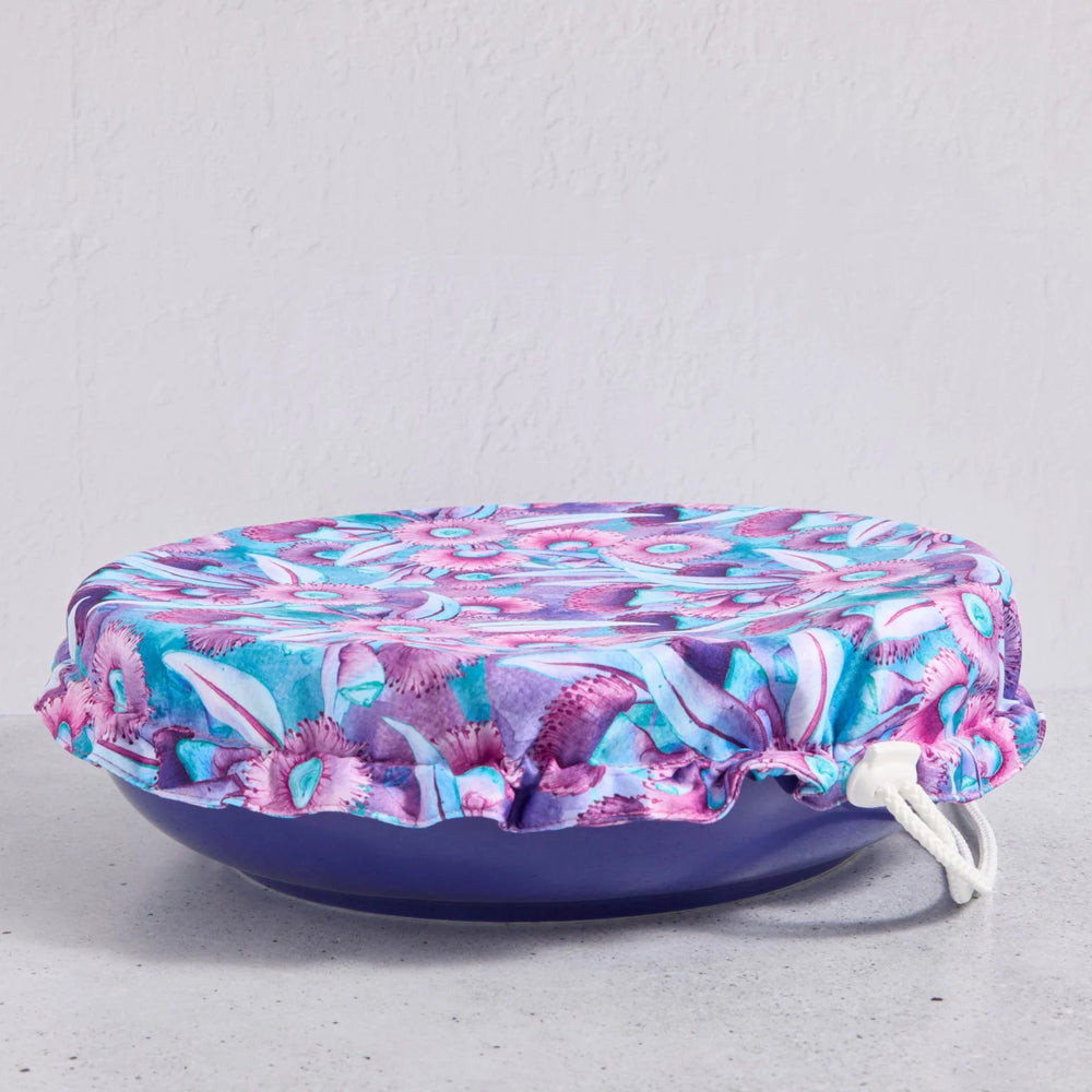 Floral bowl cover on a blue bowl on a light grey background