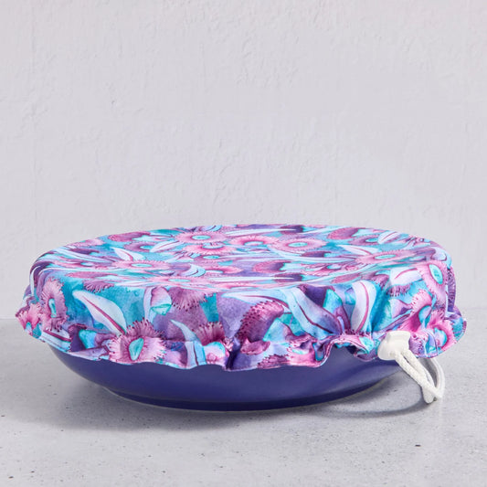 Floral bowl cover on a blue bowl on a light grey background