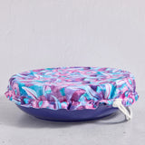 Floral bowl cover on a blue bowl on a light grey background