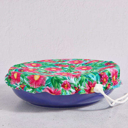 Floral bowl cover on a blue bowl on a light grey background
