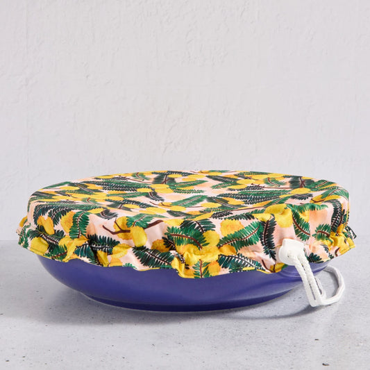 Floral bowl cover on a blue bowl on a light grey background