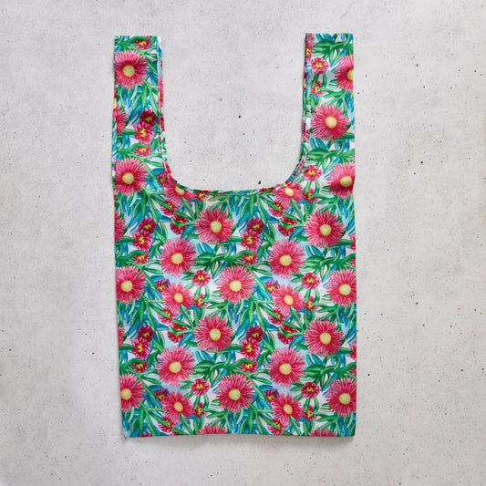 Reusable shopping bag with pink floral pattern on a concrete surface