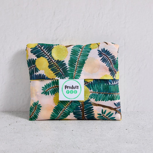 Floral-patterned shopper bag folded up with a visible brand label on a light background