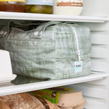 Green reusable produce bag on a fridge shelf