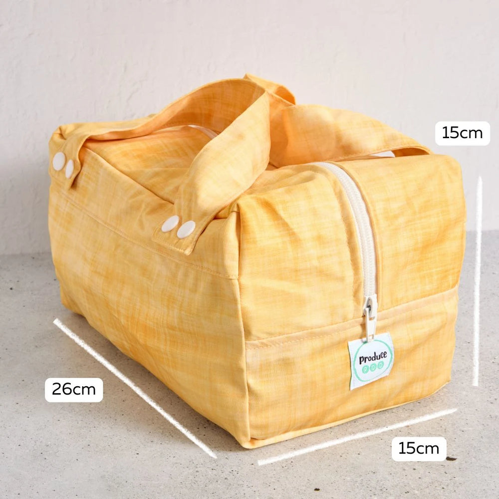 Yellow reusable produce bag with measurements on a grey background