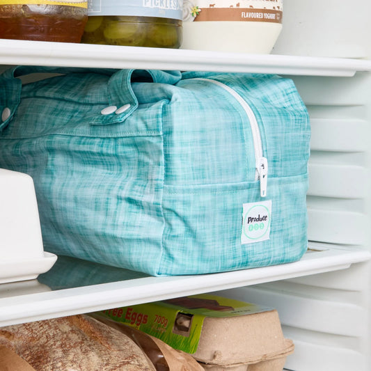 Teal reusable produce bag on a fridge shelf