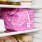 Pink reusable produce bag on a fridge shelf