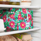 Pink floral reusable produce bag on a fridge shelf