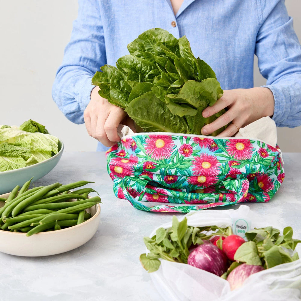 Person using a reusable produce bag with green vegetables in a kitchen