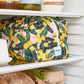 Yellow floral reusable produce bag on a fridge shelf