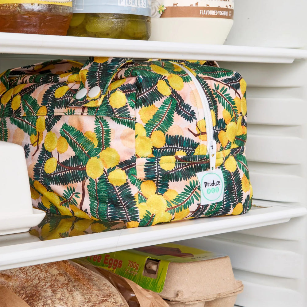 Yellow floral reusable produce bag on a fridge shelf