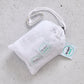 White drawstring bag with carabiner and 'Produce Pod' tags on a grey surface