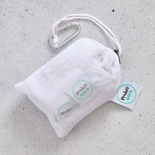 White drawstring bag with carabiner and 'Produce Pod' tags on a grey surface