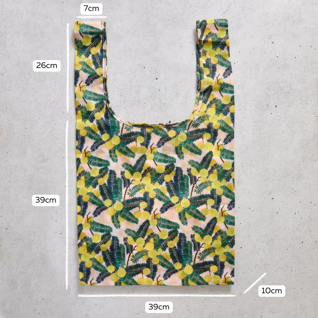 Reusable shopping bag with floral pattern and measurements on a concrete surface