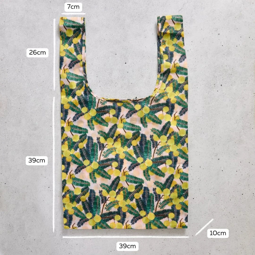 Reusable shopping bag with floral pattern and measurements on a concrete surface